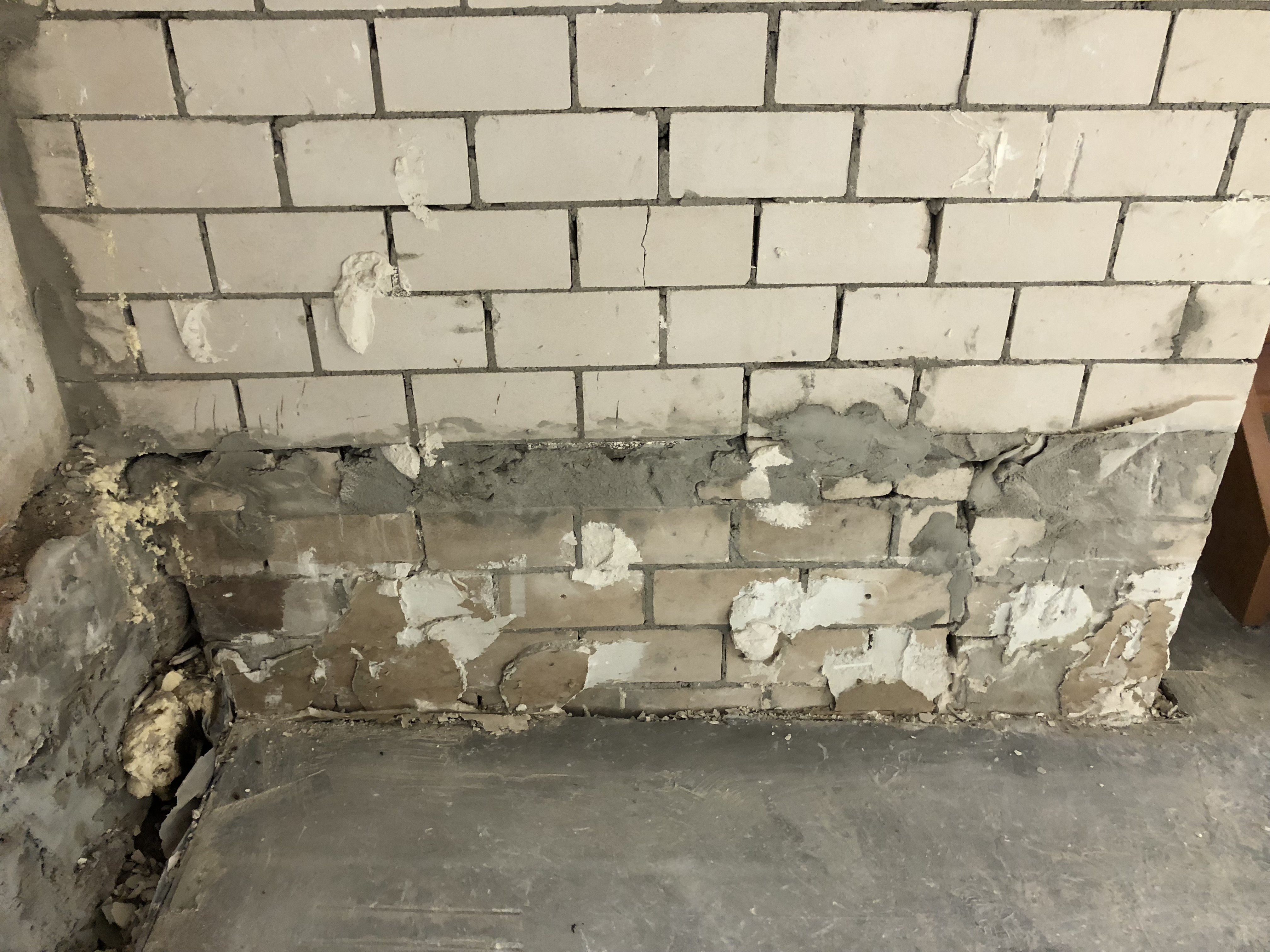 Durchfeuchtetes Mauerwerk im Sockelbereich mit Putzschäden als Folge aufsteigender Feuchtigkeit aus dem Erdreich