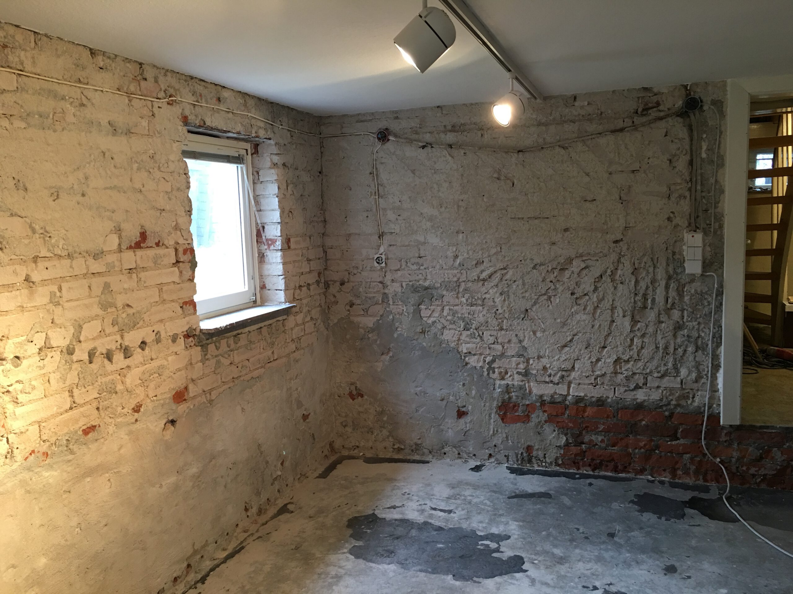 Altbau-Kellerwand freigelegt: Bohrbild früherer Horizontalsperre/Verkieselung sichtbar, Putz entfernt