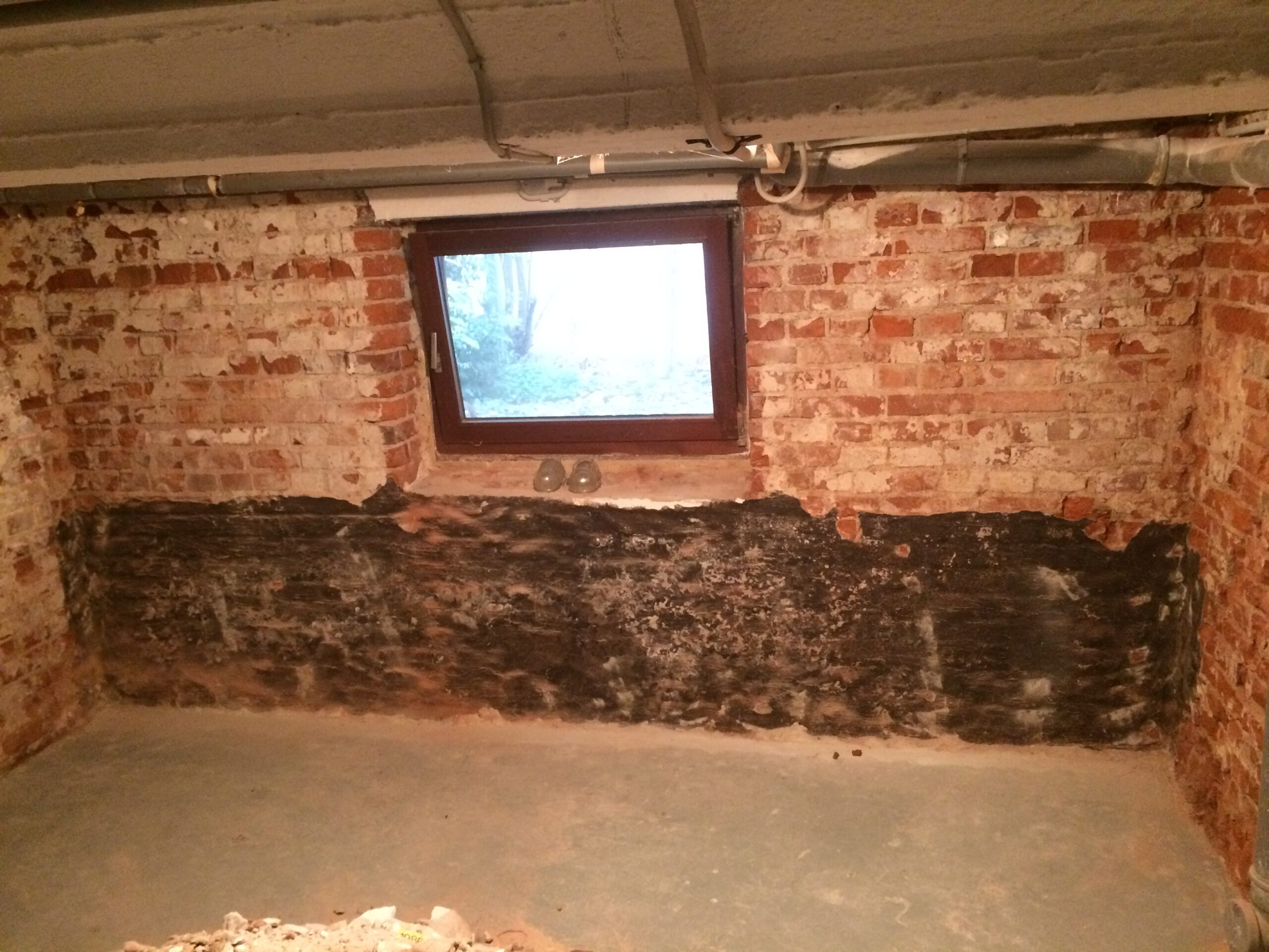 Altbaukeller Bremen-Neustadt – schwarze Beschichtung im Sockelbereich, Spuren früherer Abdichtungsversuche